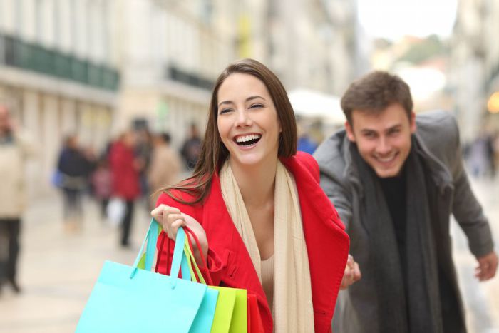 Verkaufsoffener Sonntag am 25. März 2018 Niedersachsen Bayern Hamburg Bremen - Frau zieht beim Shoppen Mann hinter sich her